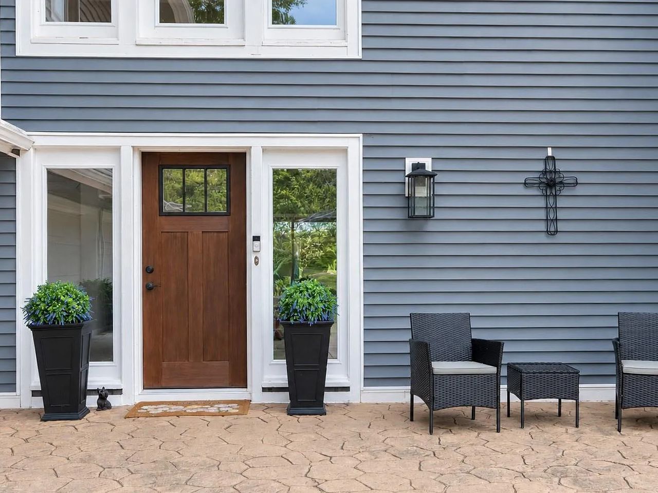 Front entry with a stained wood door, sidelights and a stamped concrete porch