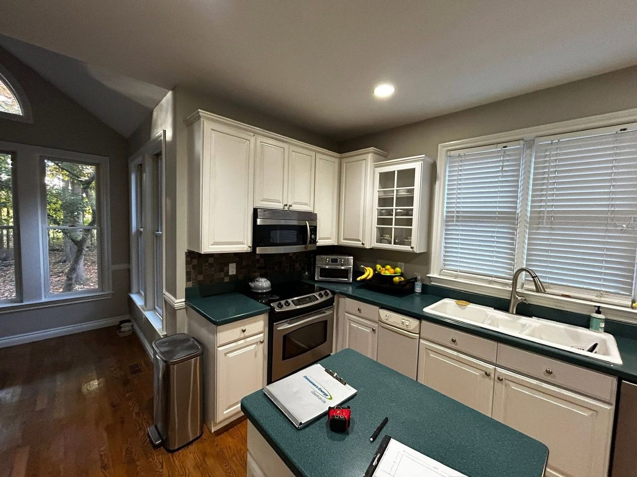 Kitchen range wall before remodeling, with tile backsplash and over-range microwave