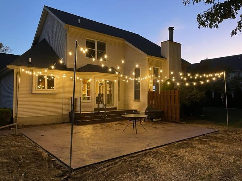 Second view of the lit concrete patio at dusk