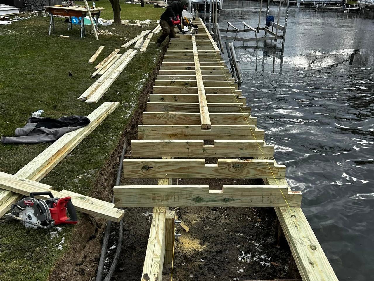 Walkway joists framed over the excavated trench alongside the water
